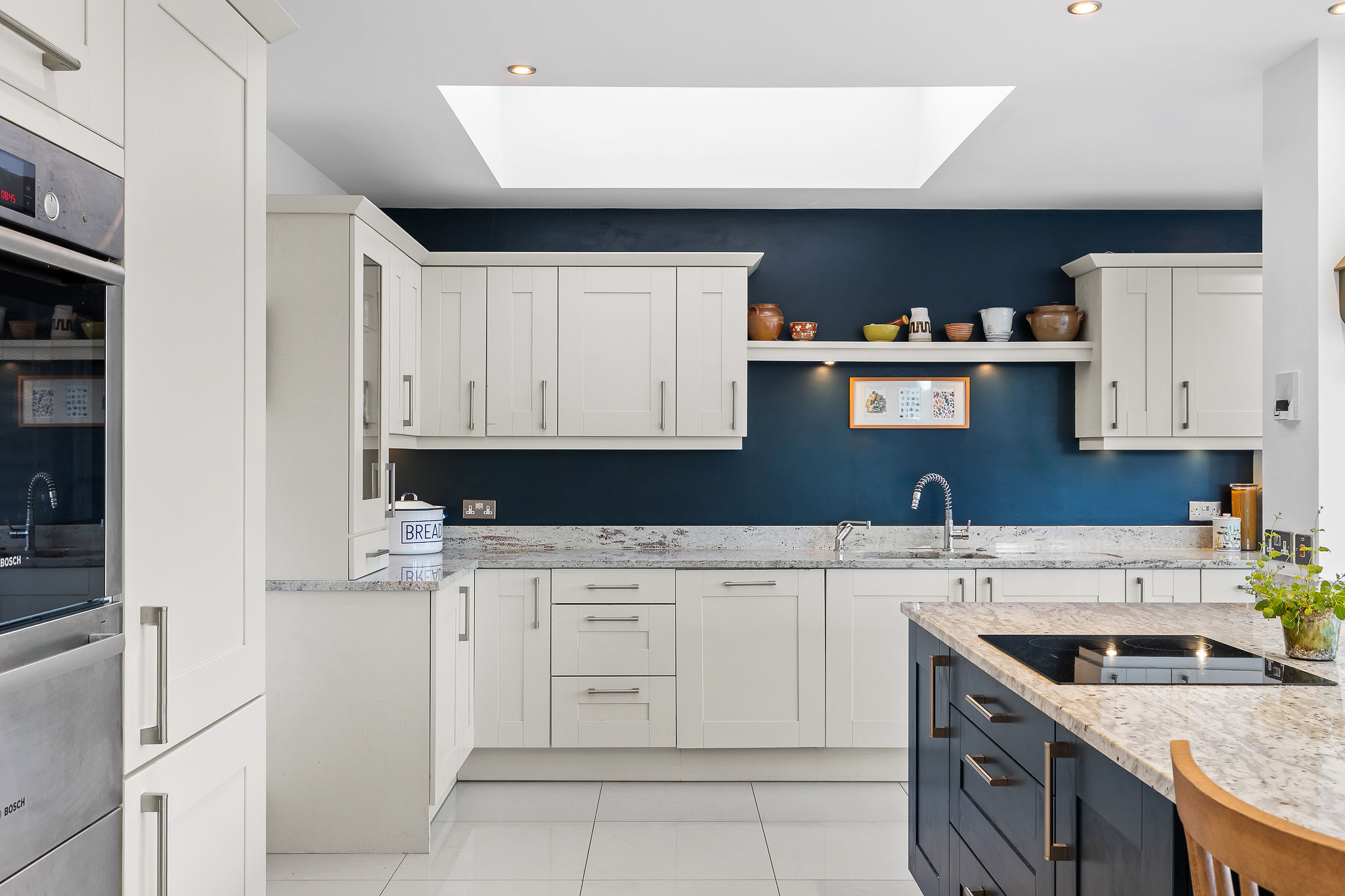 Modern kitchen interior with white cabinets and blue accent wall