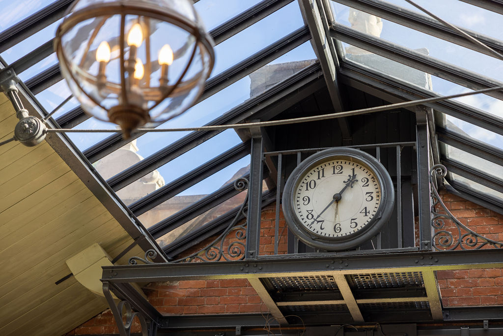 Architectural detail of glass conservatory roof with vintage clock in commercial property