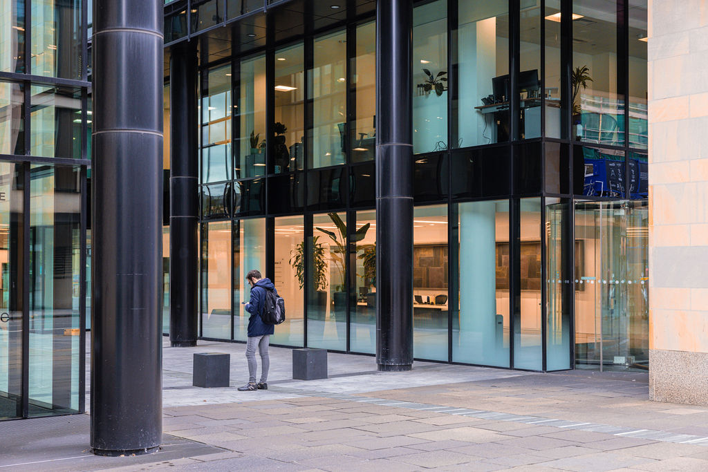 Modern commercial building exterior detail with glass facade and architectural columns