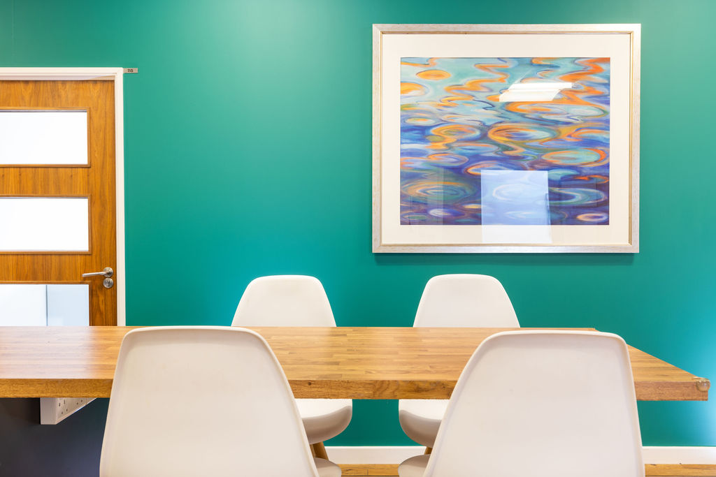 Commercial office meeting room with modern furniture and colorful artwork in Milton Keynes