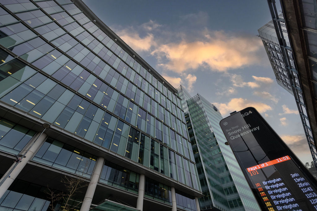 Contemporary commercial office building exterior at dusk with dramatic sky